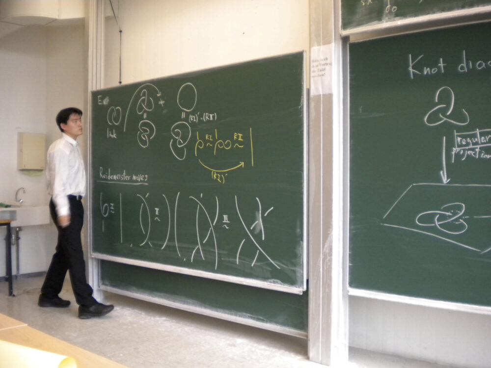 上下二段になった黒板に、イラスト等を書き、講演している伊藤先生